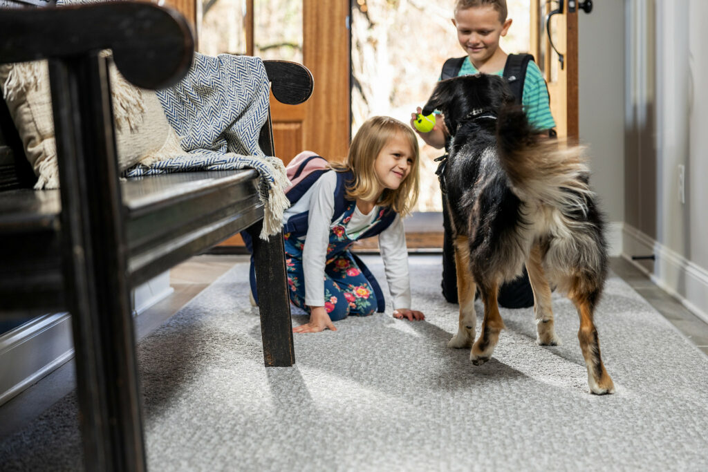 Kids plying with dog on carpet flooring | Clark Dunbar Flooring Superstore