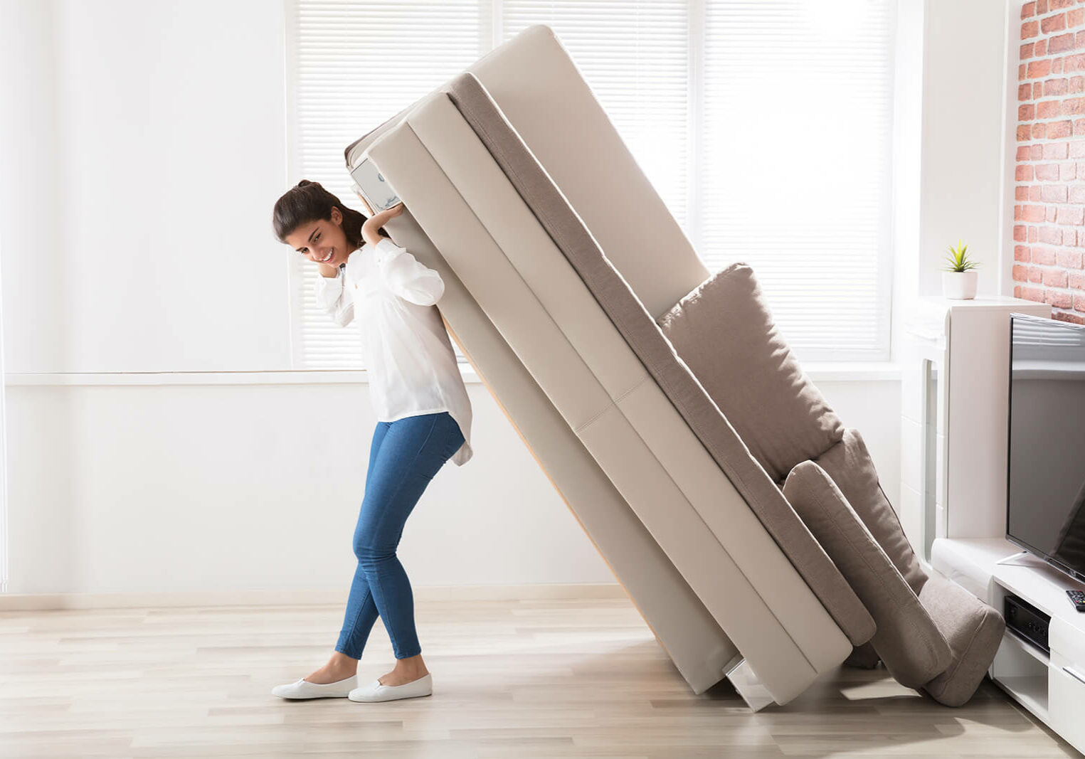 Woman moving sofa | Clark Dunbar Flooring Superstore